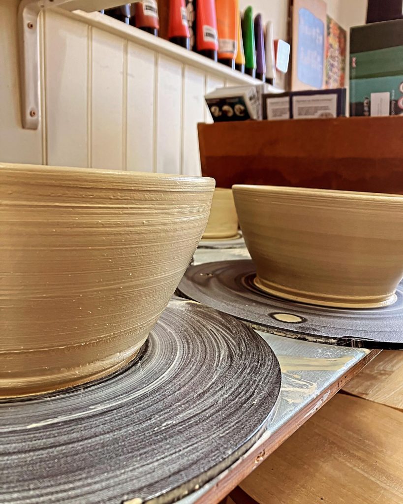 Unfinished sand coloured pottery bowls on the wheel