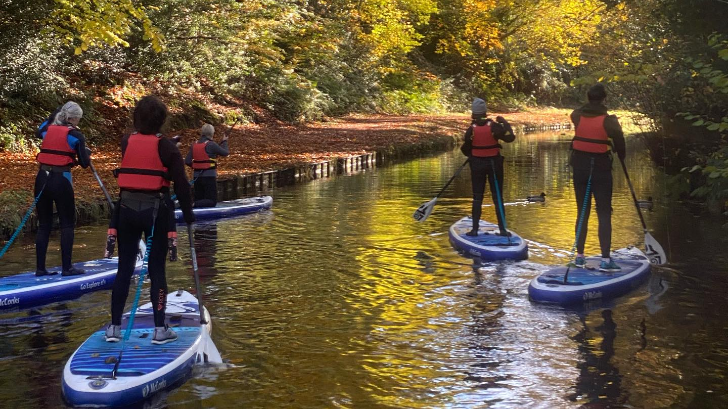 A group paddle boarding on the River Wye