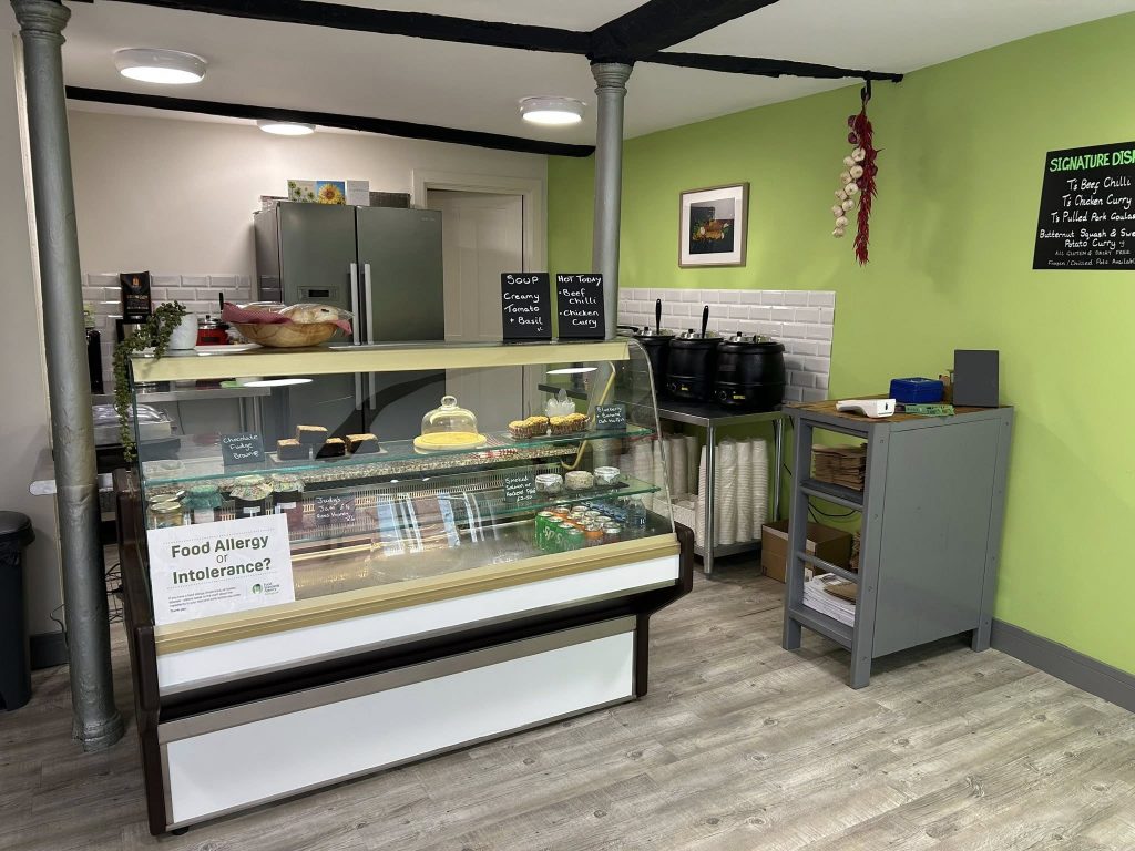 Picture of food counter and till, with green wall on the right
