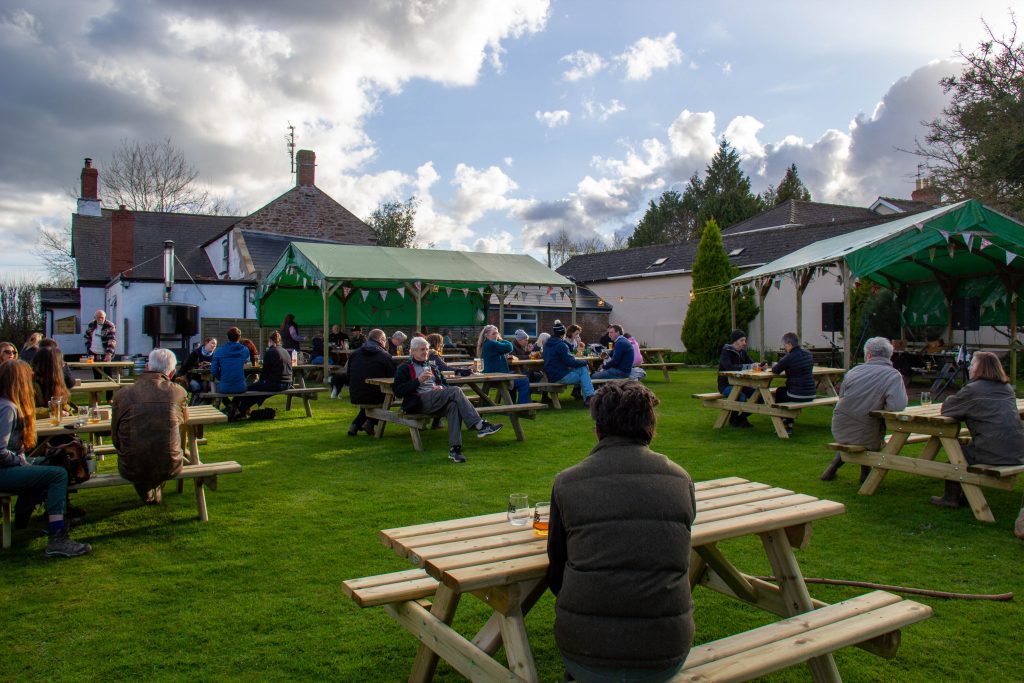 Picture of people sitting on benches with gazebos behind them
