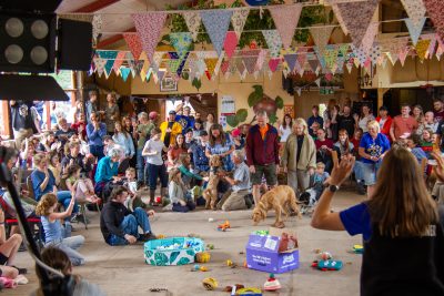 Picture of bunting hung from ceiling of hall and crowd watching dog